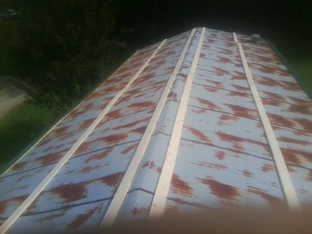 Rusted metal roof panels with new wood purlins before replacement — Storm Damage Roof Repair in Pikeville by Roofing Brothers