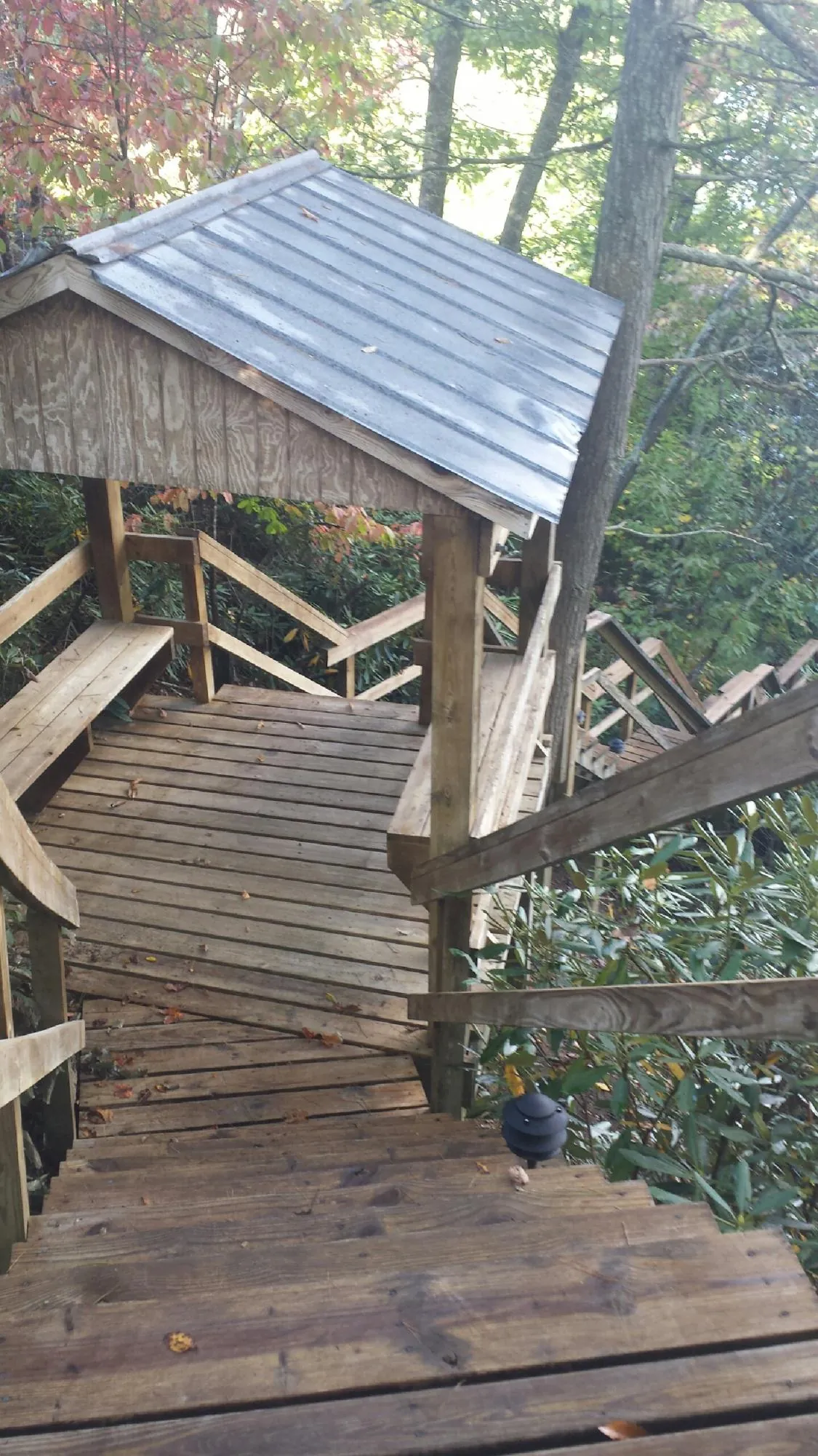 Metal roofed shelter over wooden steps on a wooded walkway — Skylight Repair & Installation work by our crew in Pikeville